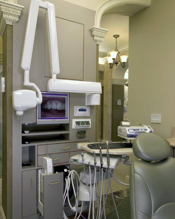 A NEXT Dentistry treatment room with a dental chair, overhead light and monitor